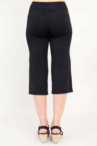 Back view of a woman wearing black yoga capri pants with black sandals