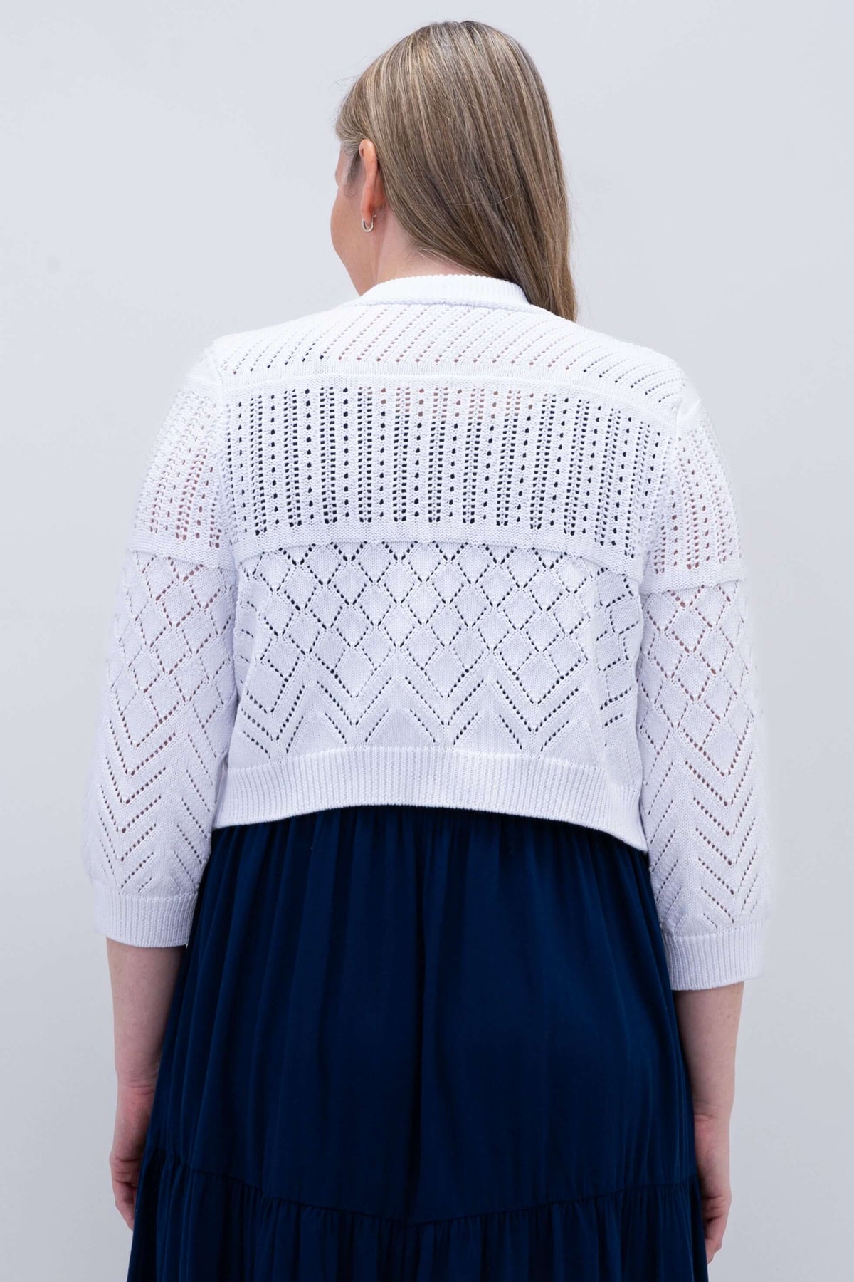 Back view of white cropped knit sweater with geometric pattern
