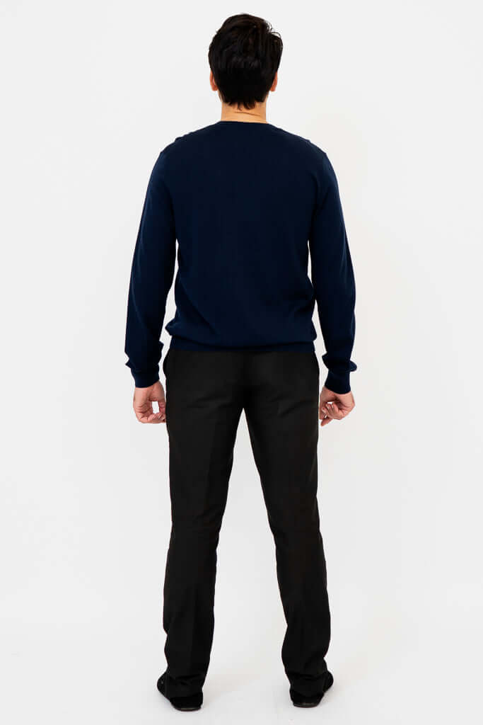 Back view of man in navy blue merino wool sweater and black pants