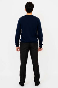Back view of man in navy blue merino wool sweater and black pants