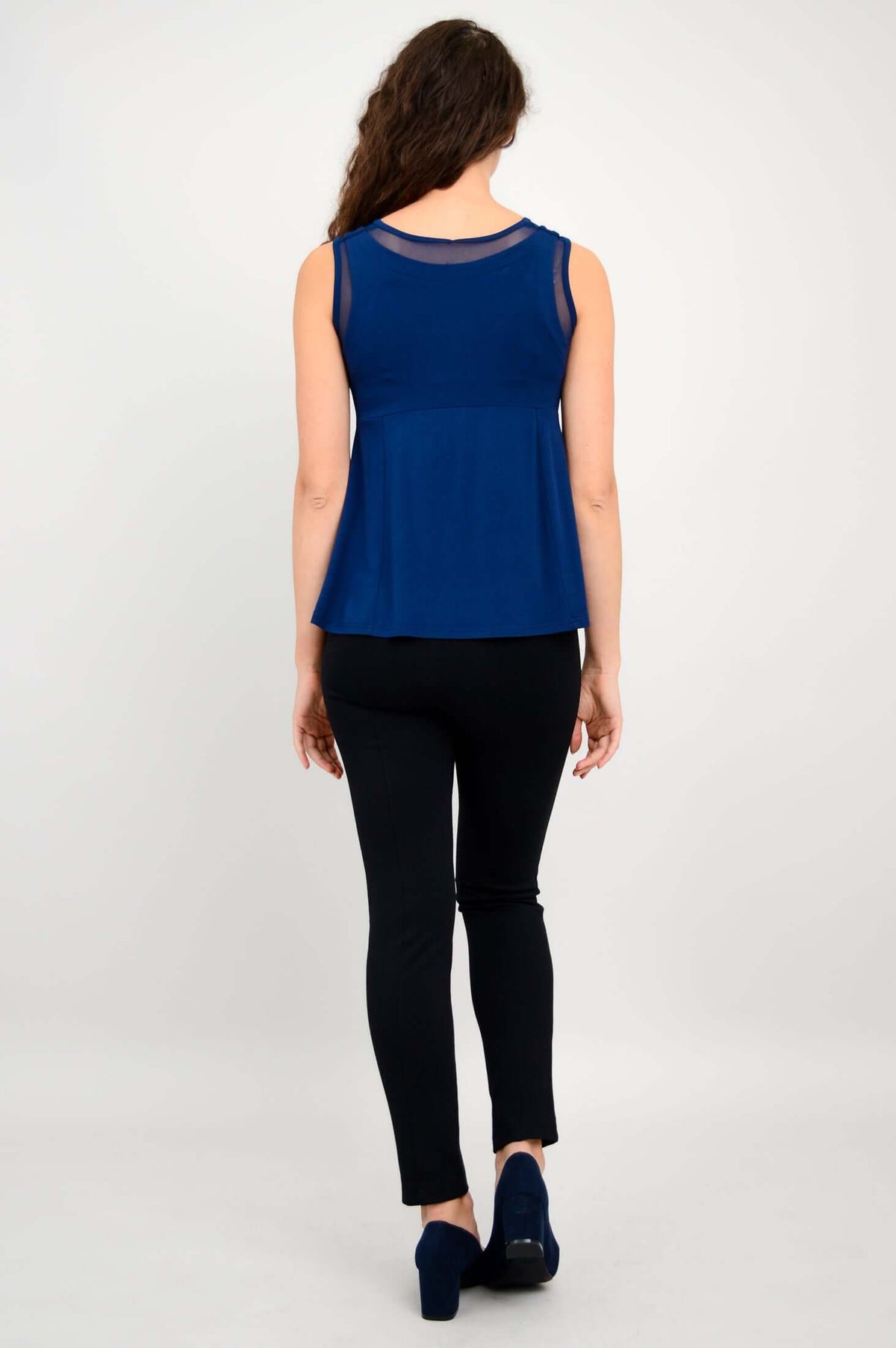 Back view of woman wearing navy mesh detail bamboo tank top and black pants