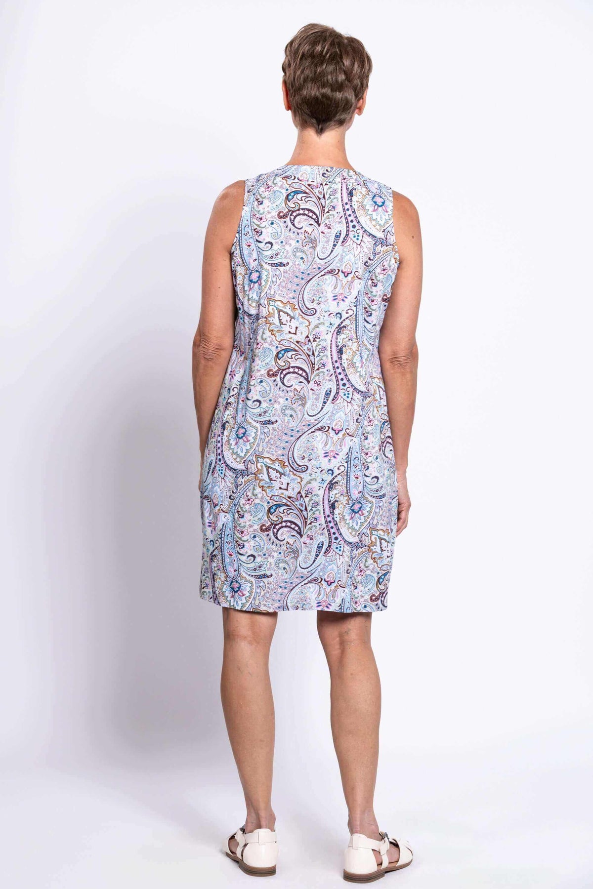Back view of a woman wearing a sleeveless paisley print shift dress