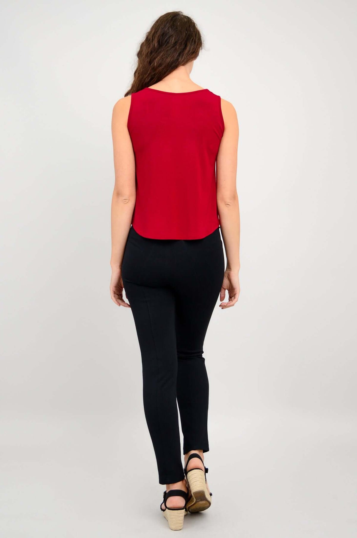 Back view of woman wearing red tank top and black pants