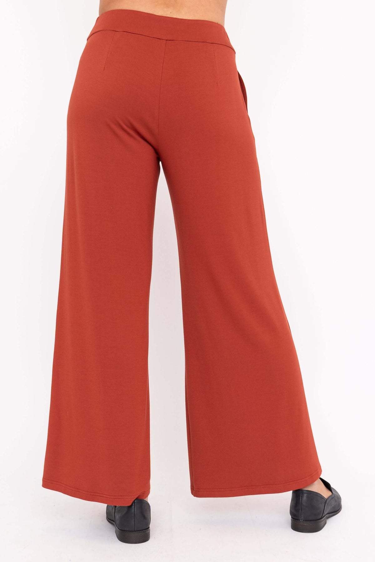 Back view of rust wide leg pants showing elastic waistband and relaxed fit