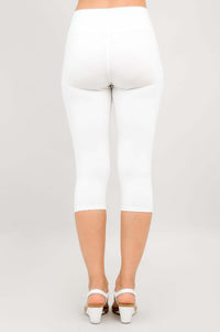 Back view of model in white capri leggings and white heeled sandals