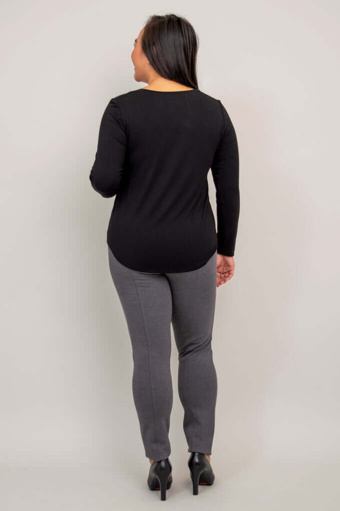 Back view of woman in black long sleeve top with rounded hem