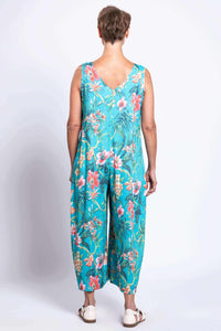 Back view of a woman wearing a turquoise floral sleeveless jumpsuit