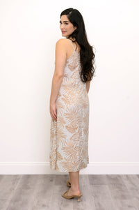 Back view of woman wearing a white and beige leaf-patterned dress against a white background