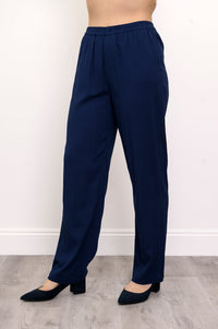 Close-up of woman wearing navy blue pants and navy blue heels on a white background