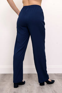 Close-up shot of woman wearing navy blue pants and navy blue heels on a white background