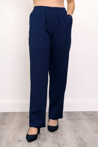 Close-up of woman wearing navy blue pants and navy blue heels on a white background