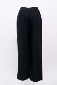 Black view of black trousers showing elastic waistband, pocket, and wide leg fits