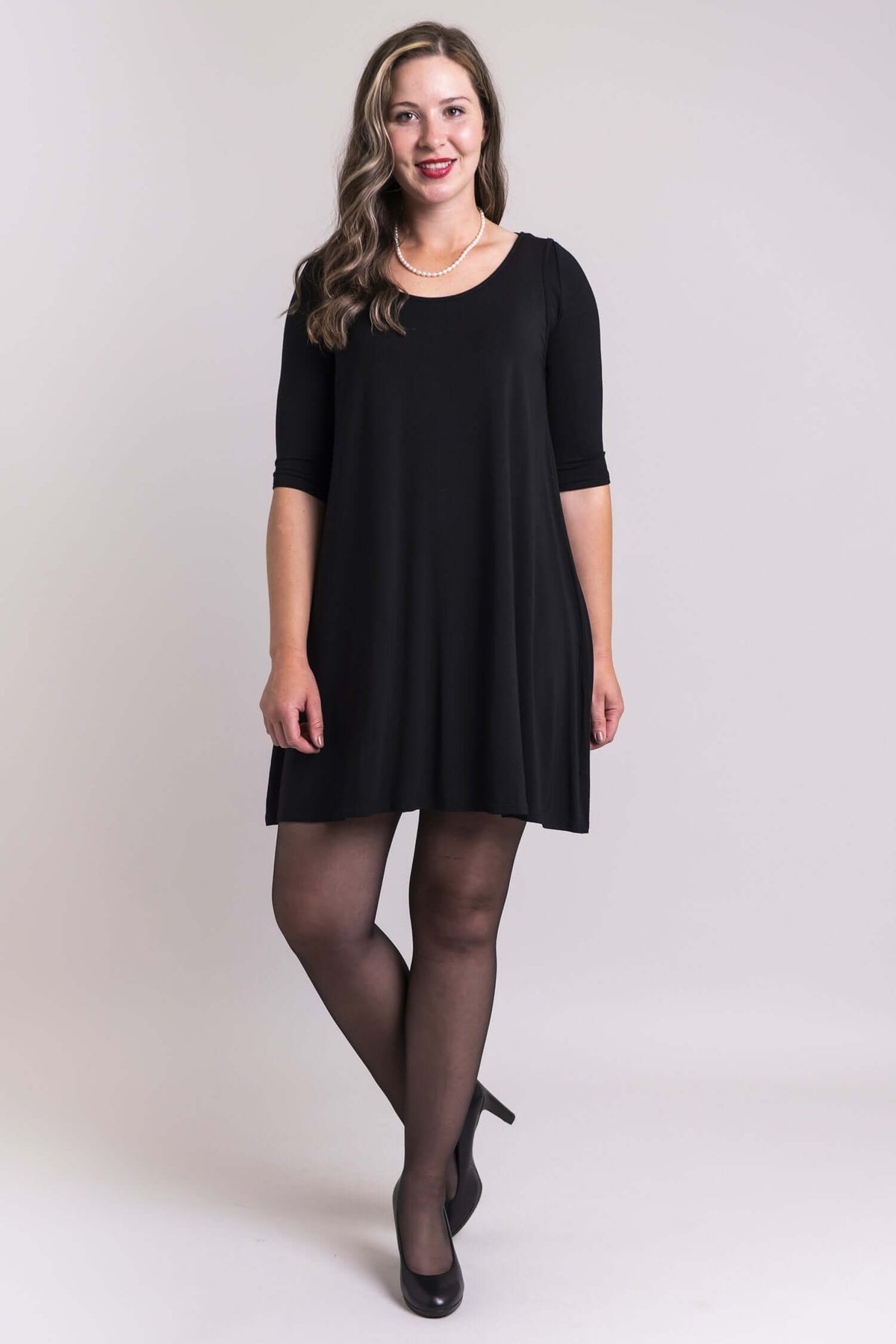 Woman in a black dress styled with a black bamboo bolero instant sleeve