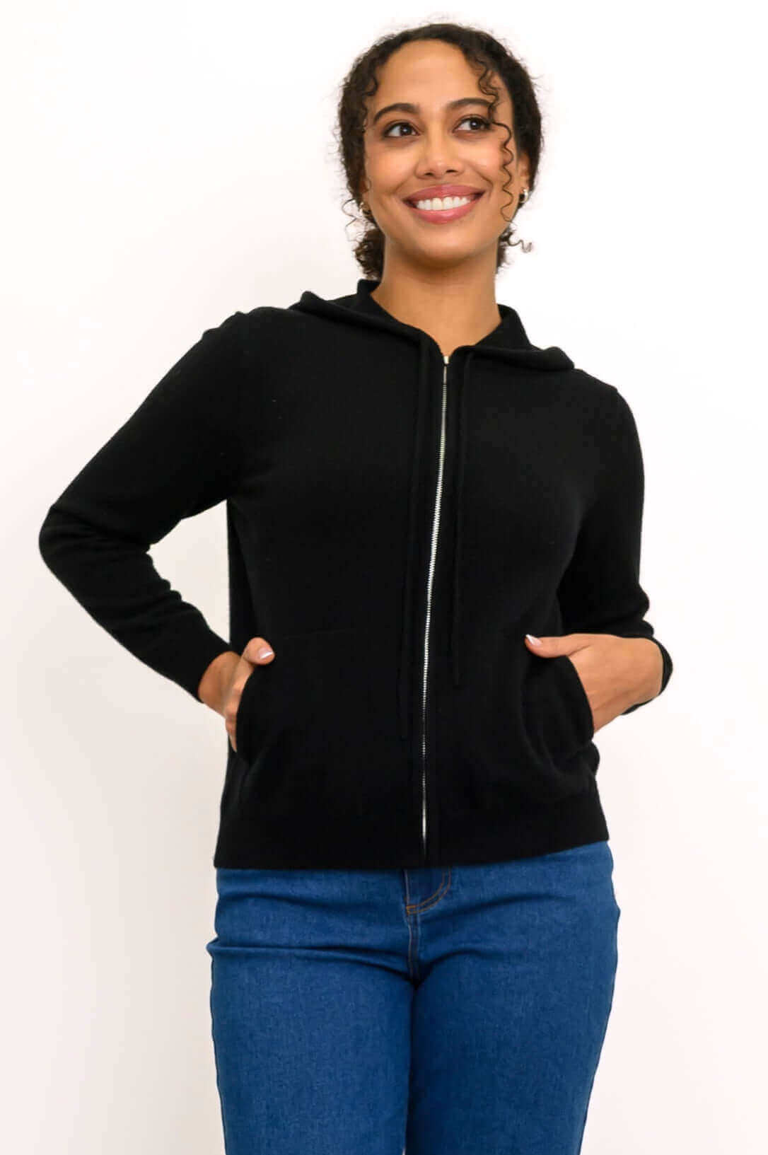 Woman wearing a black zip-front wool-cashmere hoodie with hands in pockets