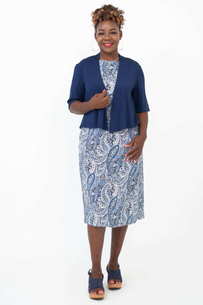 Woman in blue paisley shift dress with navy cover-up