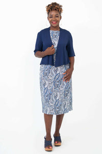 Woman in blue paisley shift dress with navy cover-up