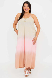 Woman standing confidently in blush ombre jumpsuit with white sandals, white background