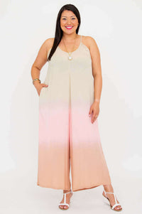 Woman wearing blush ombre wide-leg jumpsuit with spaghetti straps, posing against a white background