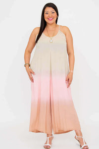 Woman smiling brightly in blush ombre wide-leg jumpsuit, standing against white backdrop