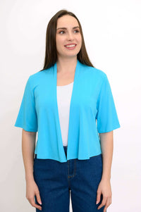 Model wearing a bright blue cropped open-front short sleeve jacket over a white shirt