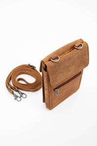 Angled view of a brown leather crossbody wallet with detachable strap