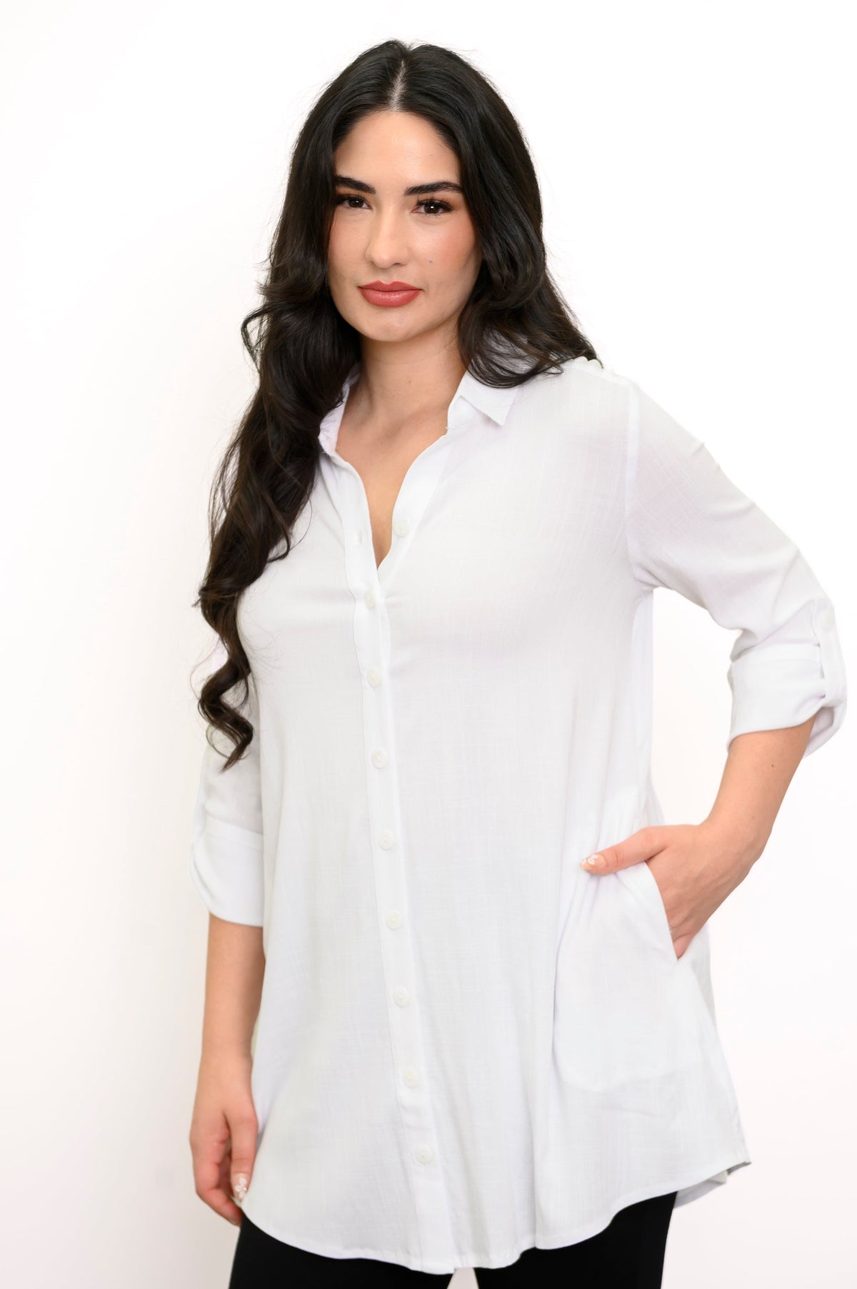 Close up of woman putting her hand in the pocket of her white button-up blouse