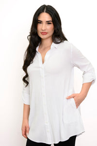 Close up of woman putting her hand in the pocket of her white button-up blouse