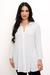 Close up front view of woman wearing a long sleeve white button up blouse and black pants
