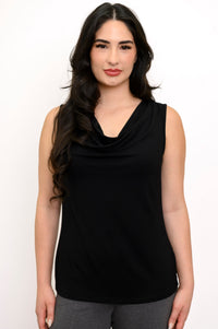Close up of woman wearing a black cowl neck sleeveless top and grey pants