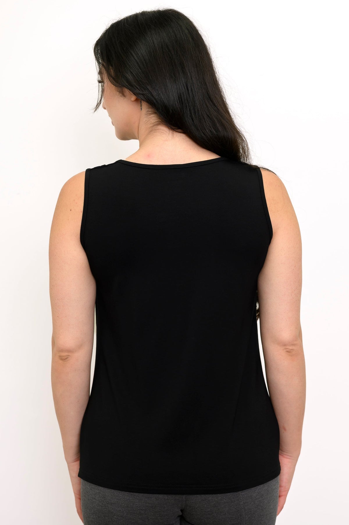Back view of woman wearng a black tank top and grey pants
