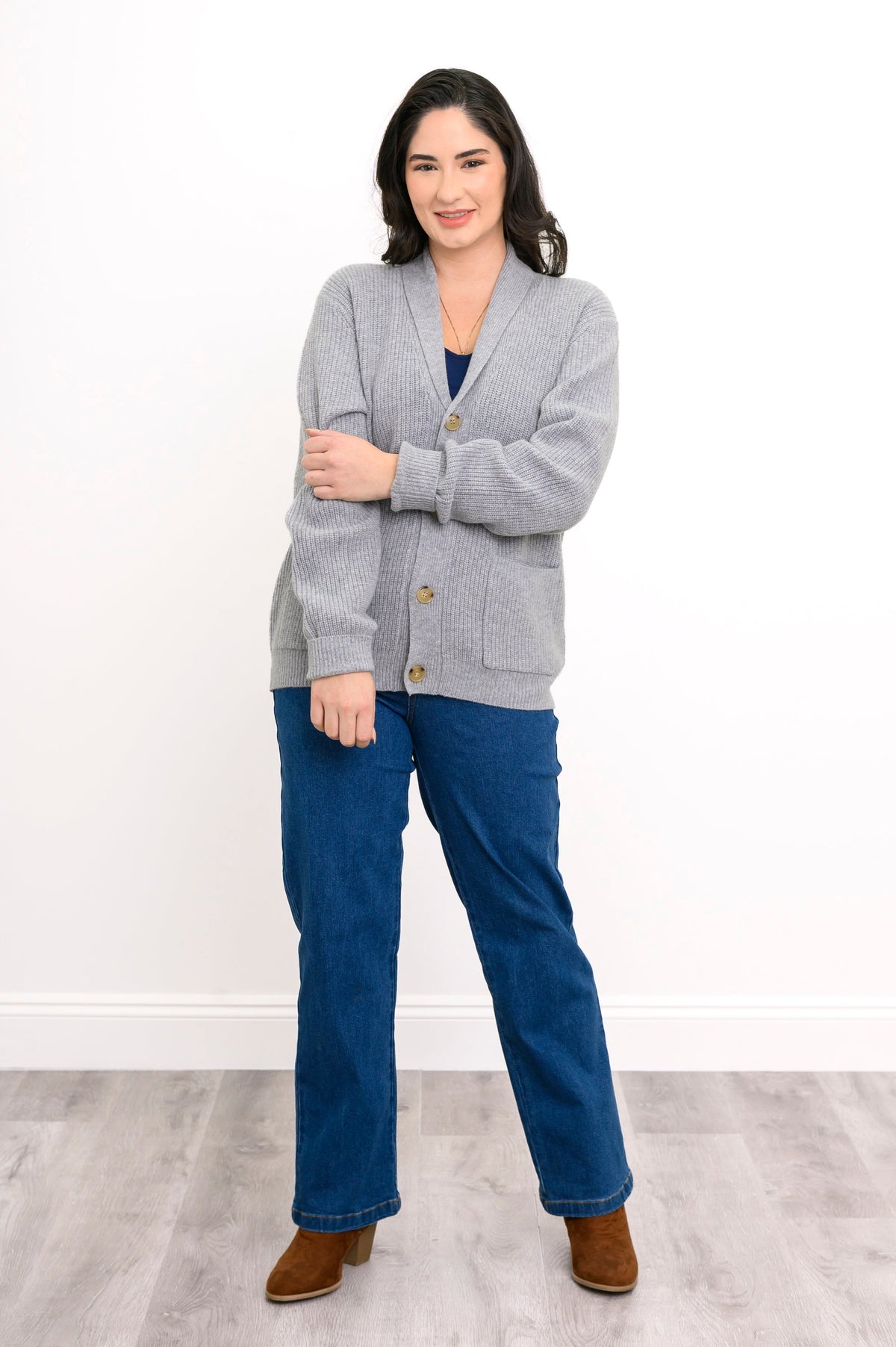 woman modelling a light grey shawl collar cardigan with front pockets