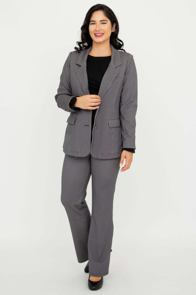 Woman confidently posing in a classic checkered blazer and trousers set