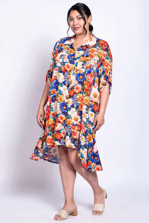 Model posing in a colorful floral Nora dress with pockets and tabbed sleeves