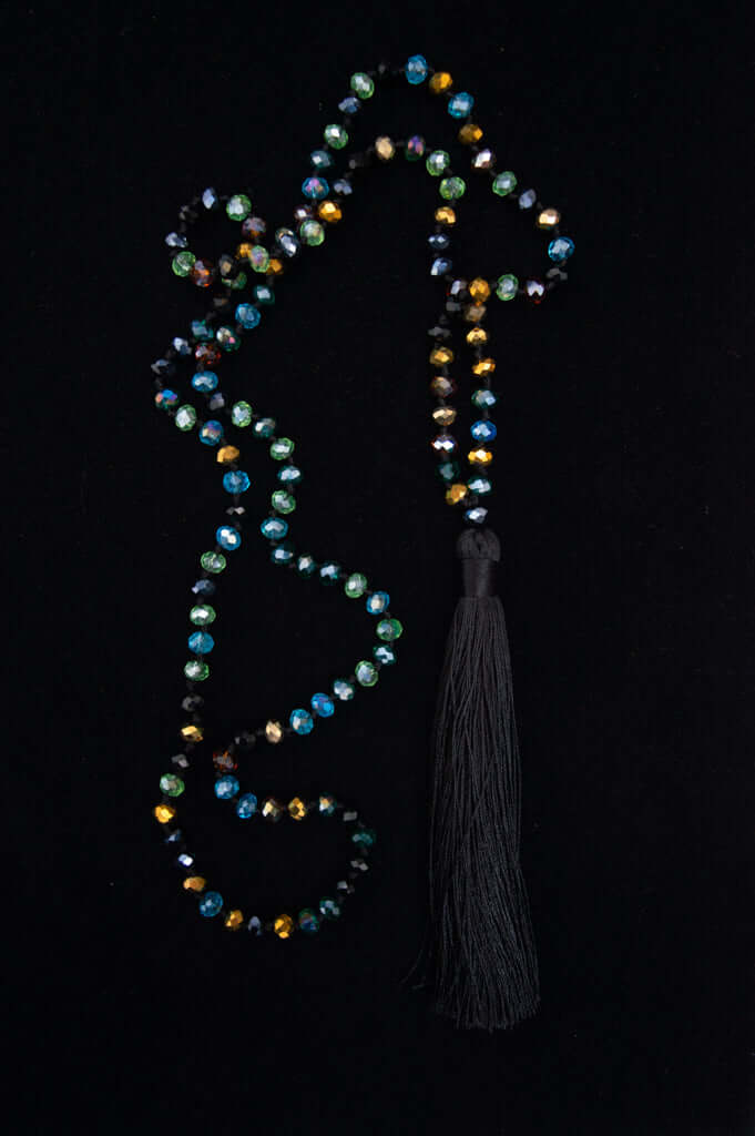 Multicolor crystal beaded necklace with a black tassel on a black background