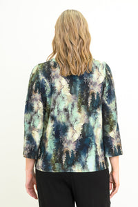 Back view of a female model wearing a watercolor green top with long sleeves with black pants, against a white backdrop