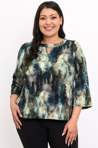 Front view of a plus size female model wearing a watercolor green top with long sleeves with black pants, against a white backdrop