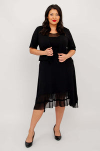 Model posing in black mesh hem dress and short sleeve black jacket