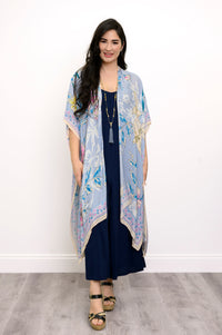 Front view of woman wearing a light blue floral kimono on a navy outfit against a white background