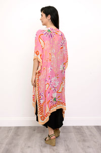 Back view of woman wearing a pink floral kimono on a black outfit against a white background