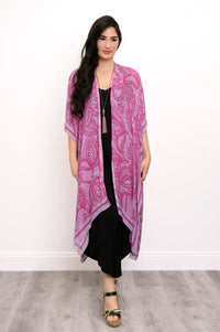 Front view of woman wearing pink and purple lace patterned kimono on a black outfit against a white background
