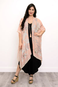 Front view of woman wearing pink floral patterned kimono on a black outfit against a white background