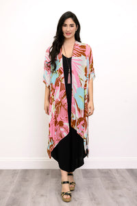 Front view of woman wearing multicolor tropcial patterned kimono on a black outfit against a white background