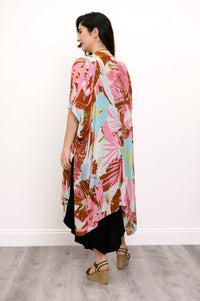 Back view of woman wearing multicolor tropcial patterned kimono on a black outfit against a white background