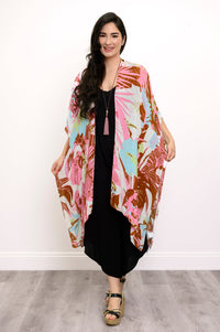 Front view of woman wearing multicolor tropcial patterned kimono on a black outfit against a white background