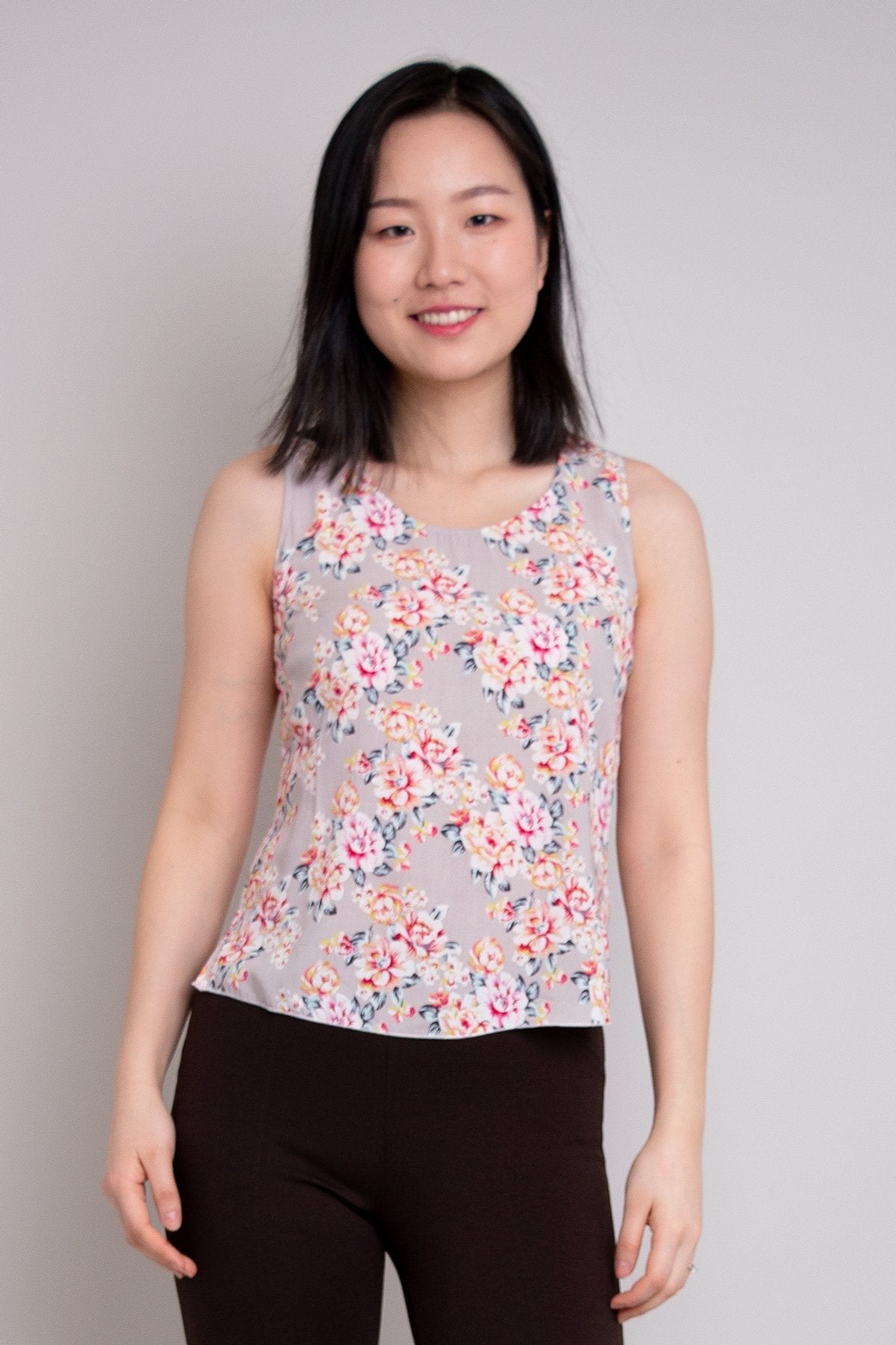 Women's pink rose floral print sleeveless muscle tank top with wide shoulder straps and scoop neck, made from natural bamboo fibers.