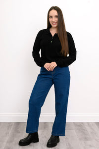 Full body front view of woman wearing 1/4 button up jumper, straight-leg jeans, and black boots