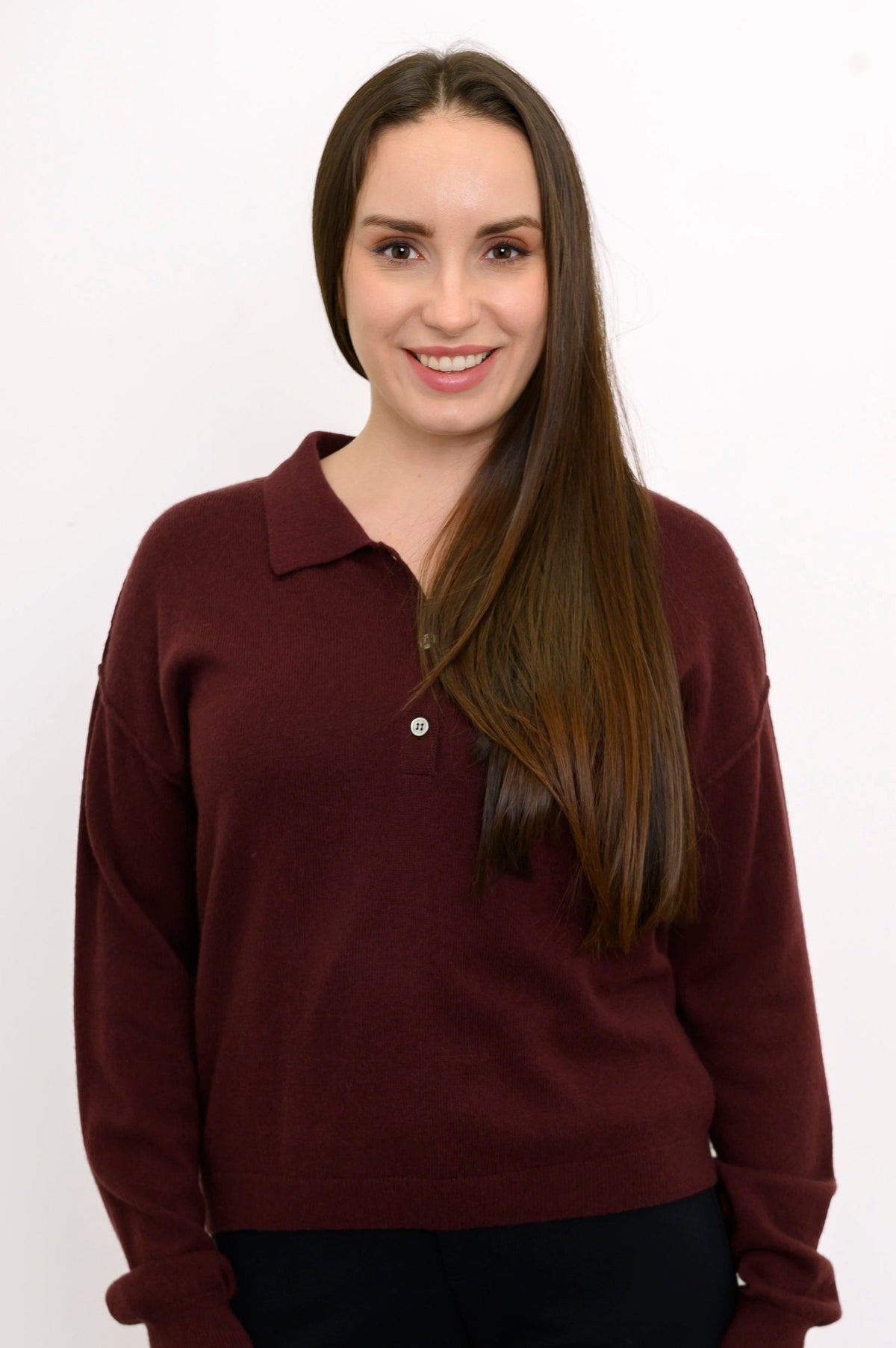 Close-up front view of woman wearing dark burgundy sweater with classic collar and 1/4 buttons