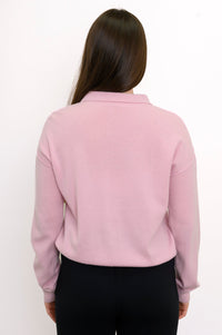 Close-up back view of woman wearing long sleeve light pink cashmere sweater with drop sleeves
