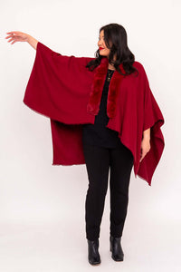 Woman showcasing extended drape of red wrap with arm raised