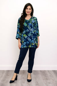 Woman wearing a blue and green floral top and navy pants against a white background, front view